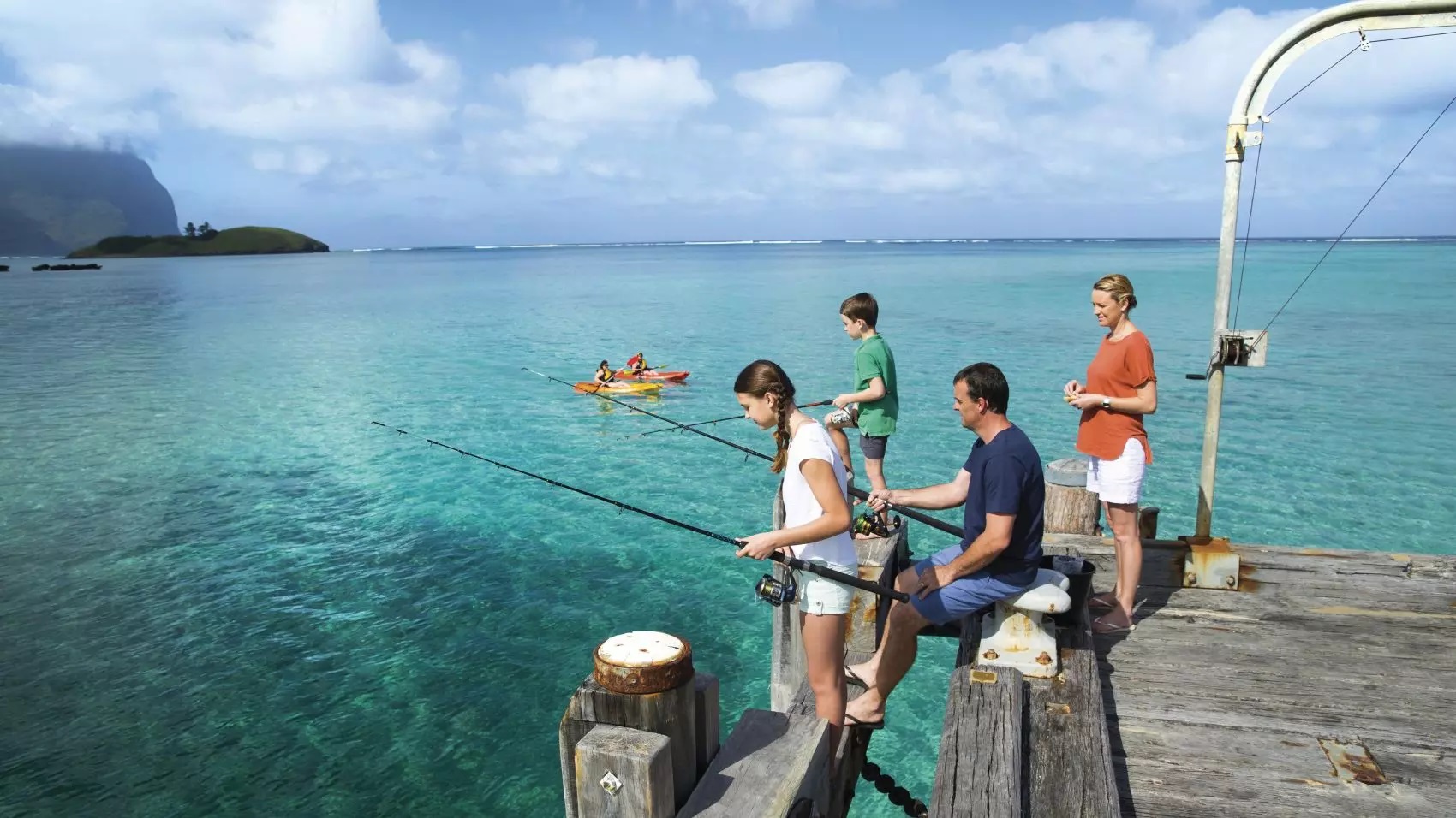 People on a wooden wharf fishing with rods at Lord Howe island